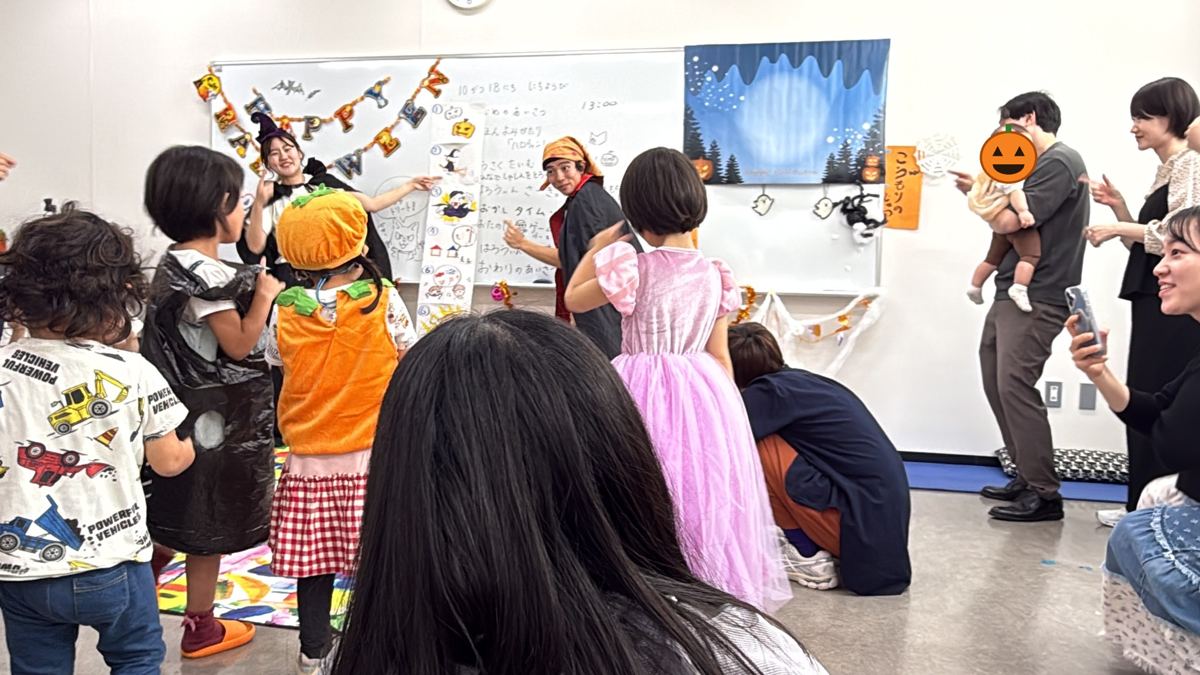 仮装した子どもたちとスタッフが輪になって踊る様子